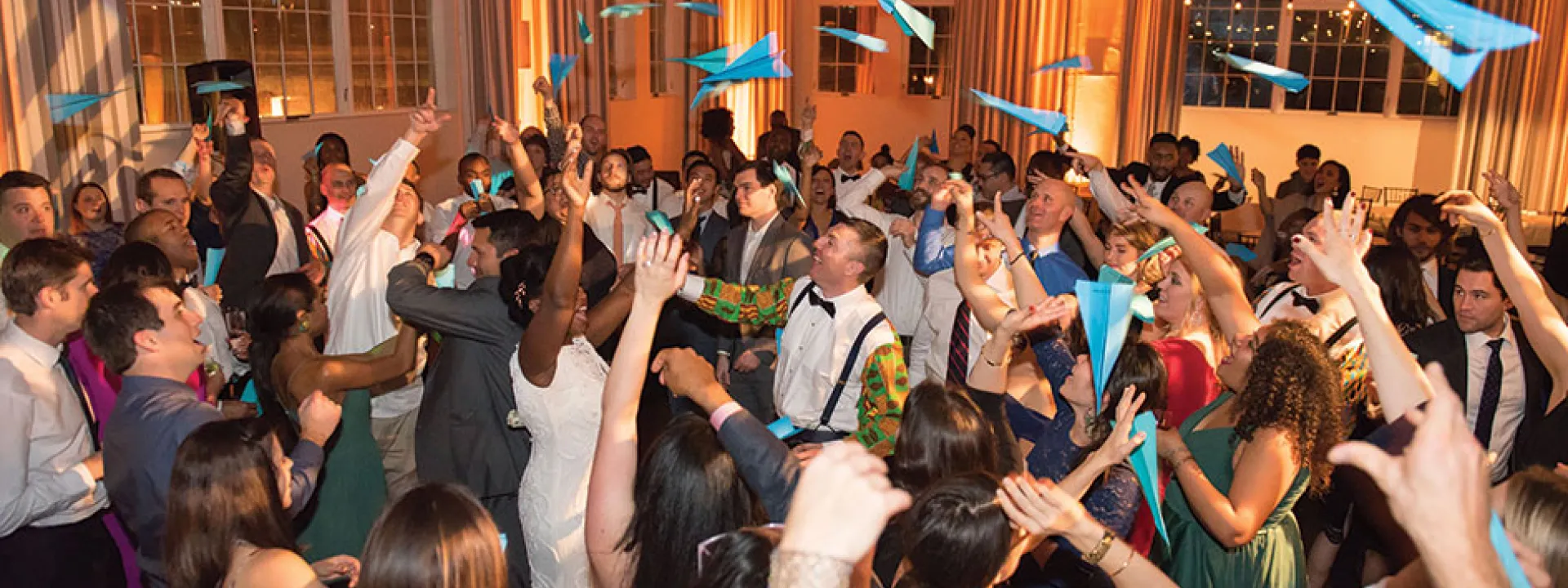 A paper-airplane toss at this travel-themed wedding lent a fun moment to the dance party.
